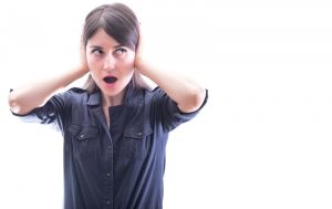 woman-covering-her-ears-wearing-blue-button-ups