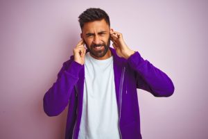 person-cringing-and-covering-their-ears